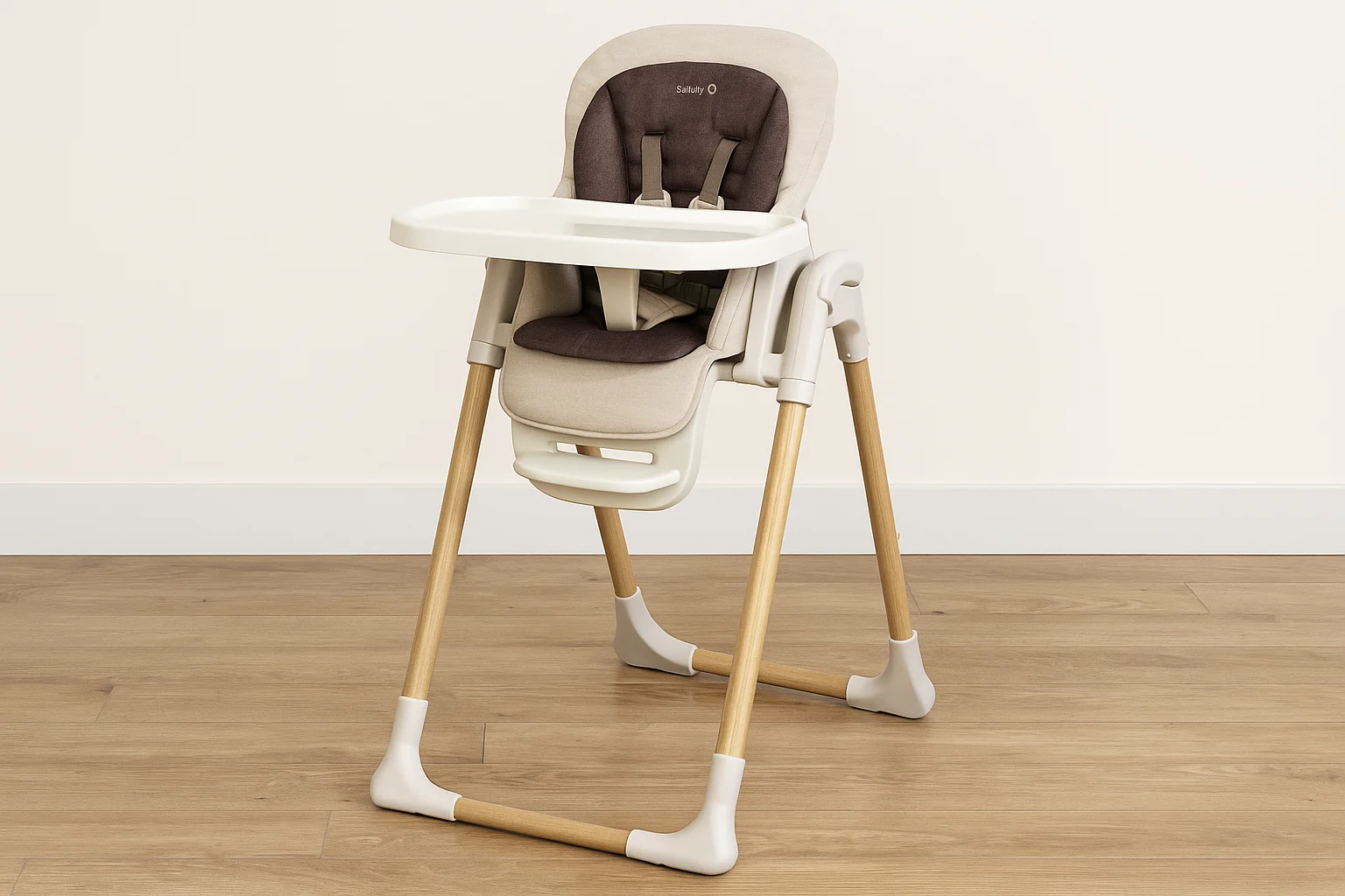 Modern beige and brown high chair with wooden legs and a detachable tray, placed on a light wood floor against a cream wall.
